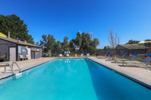 a swimming pool with chairs and a fence
